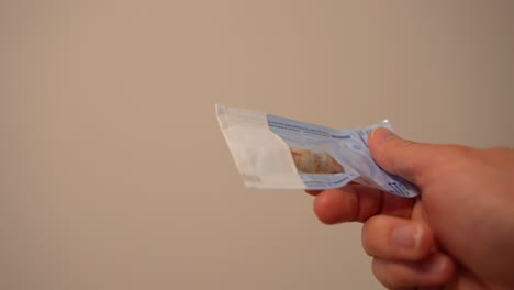 Unrecognisable-adult-holding-a-bag-of-extracted-blooded-wisdom-teeth,-close-up