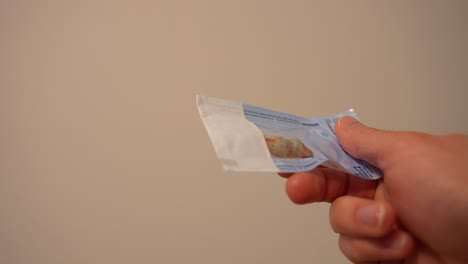 adulto irreconocible sosteniendo una bolsa de dientes del juicio extirpados con sangre, de cerca