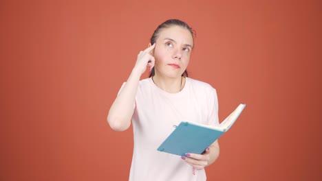 woman with notebook thinks and takes notes.