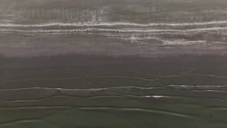 olas que chocan contra la orilla, disparo aéreo de arriba hacia abajo, alto, olas abstractas y pacíficas del océano, playa poco profunda