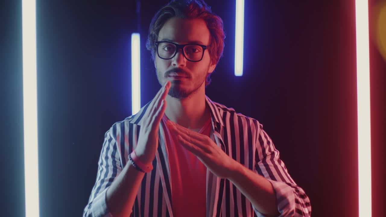 Man in Striped Shirt Under Neon Lights