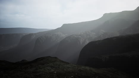 Dunkle-Atmosphärische-Landschaft-Mit-Hohem-Schwarzen-Berggipfel-Im-Nebel