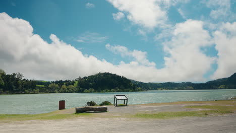 wide shot of calm colorful mountain lake surrounded by green lush vegetation