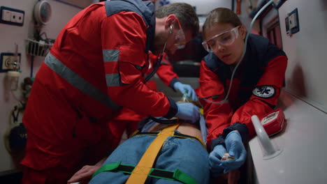 mixed race doctors providing medical help of patient in ambulance car