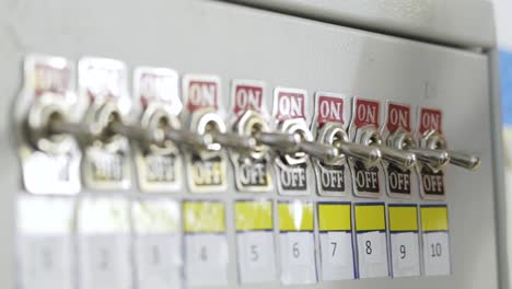 close-up of hand operating switches on an electrical panel