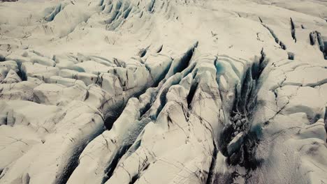 Glacier-tongue-in-Iceland-filmed-by-drone-with-different-cinematic-movements,-showing-a-cloudy,-dramatic-concept-in-wintery-conditions