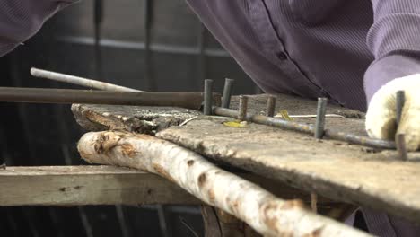 trabajador dobla la línea de acero en forma cuadrada. para el edificio de construcción
