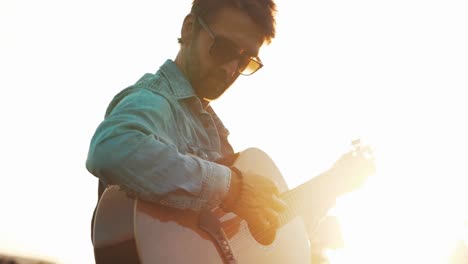 Goldene-Stunde-Filmischer-Sonnenuntergang-Musiker,-Der-Gitarre-Im-Feld-Spielt