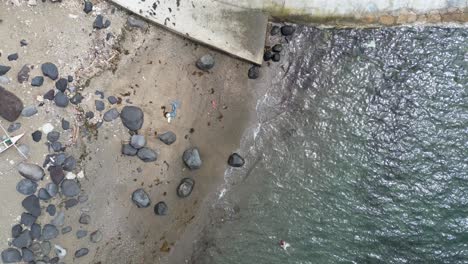 birdseye view of rocky beach, swimmers, and coastal bike path road