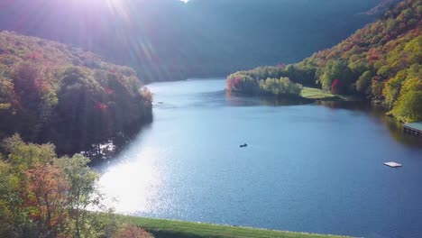 Aerial-over-canoe-on-lake-surrounded-by-vast-forests-of-fall-foliage-and-color-in-Maine-or-New-England