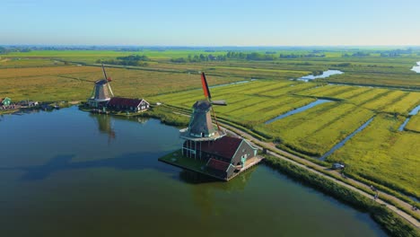 dutch windmills next to zaan river at zaanse schans polder summer drone