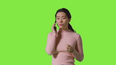 여성이 휴대전화로 대화하고 녹색 화면에 대해 나쁜 소식을 듣는 스튜디오