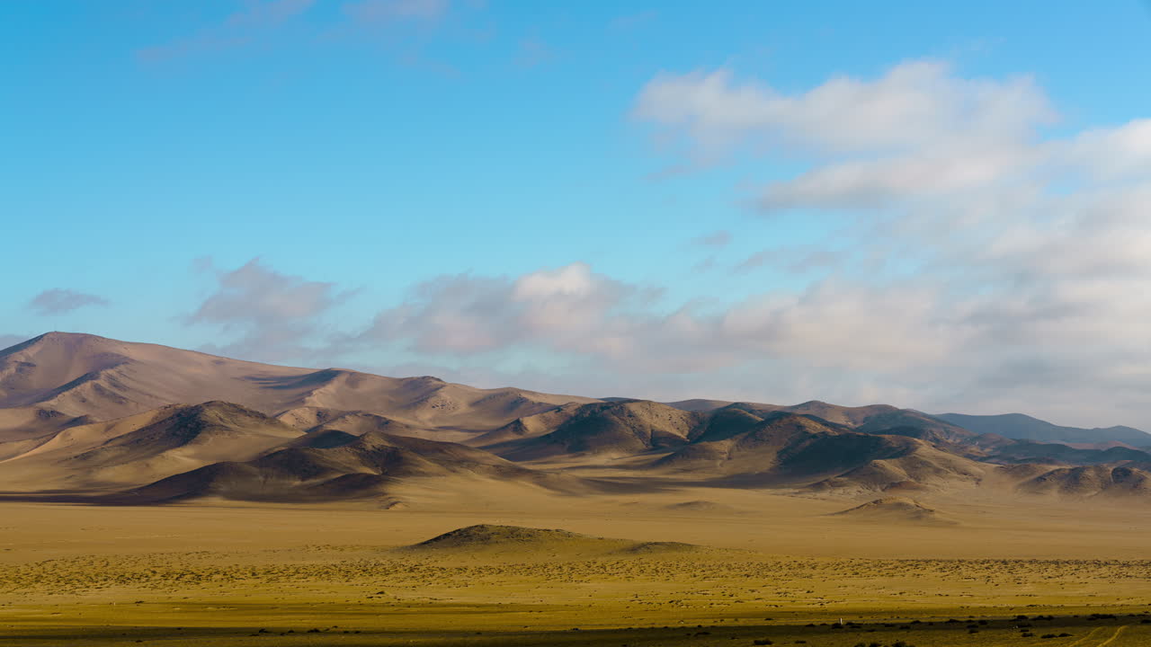 구름이 머리 위로 움직이는 것을 보여주는 밝고 화창한 날 사막 풍경의 저속