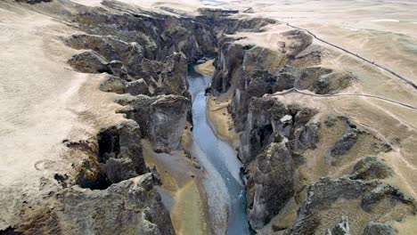 Island-Film-Naturdrohne,-Die-über-Eine-Tiefe,-Dramatische-Schlucht-Mit-Zerklüfteten-Klippen-Fliegt