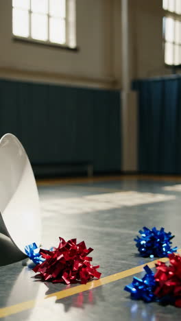 cheerleading pom-poms in an empty gym