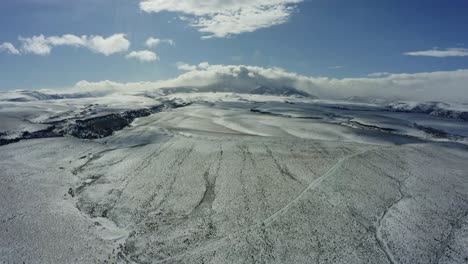 Langsam-Nach-Vorne-Fahrende-Drohnenaufnahme-Einer-Schneebedeckten,-Weitläufigen-Ebene