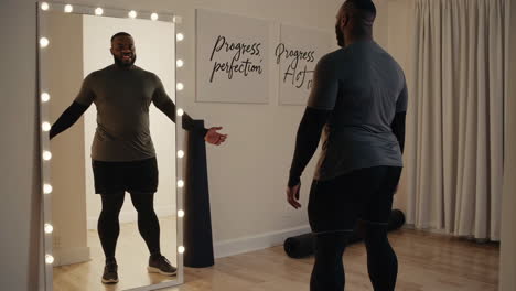 man looking at himself in the mirror, feeling good about his progress