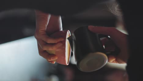 vertical, closeup on coffee latte art being made by apprentice barista