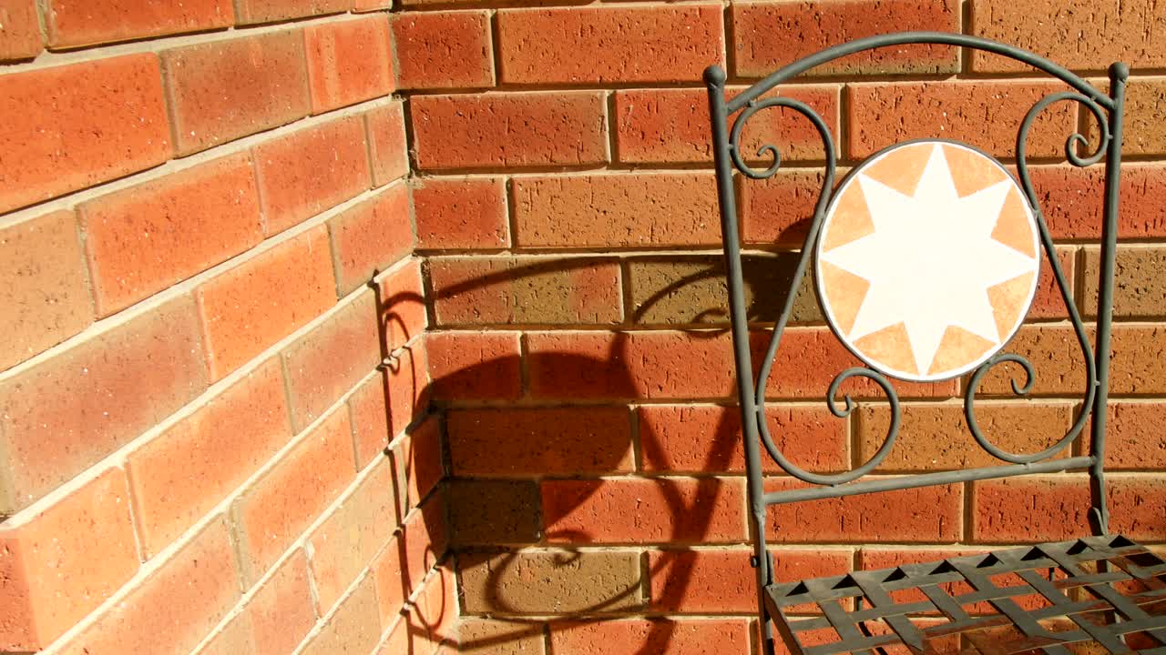 벽돌 벽에 의자 그림자의 시간 경과