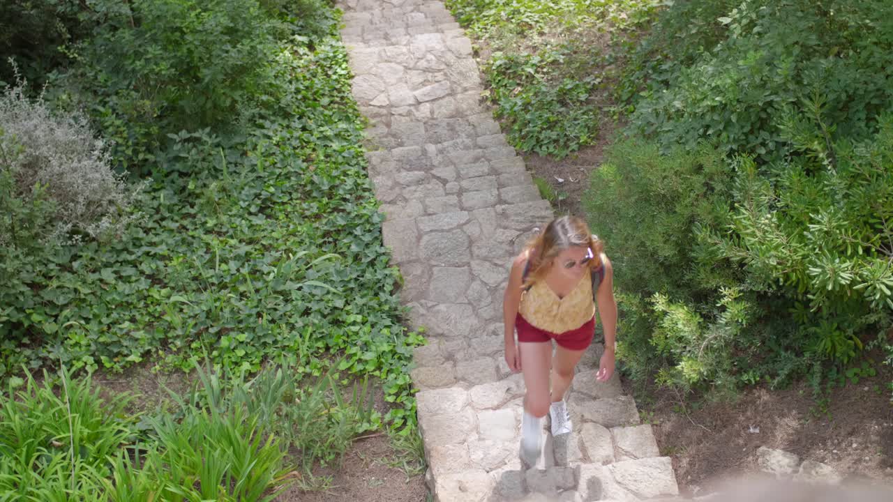 mochilero mujer caminando en spring park - ángulo alto