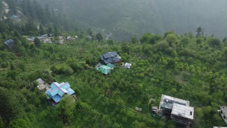aerial view short of jibhi himachal pradesh in india. houses and trees in the mountainous area. faguli festival is one of the biggest festival in jibhi. the traditional houses here have stone roofs.