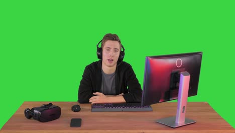 young man in headset giving a speech to camera on a green screen, chroma key