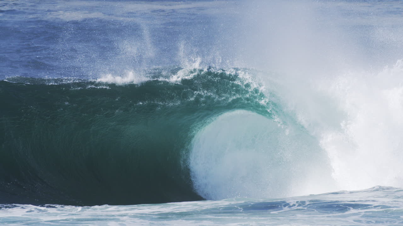 Crashing ocean wave with rising mist and glowing texture, shot in slow motion