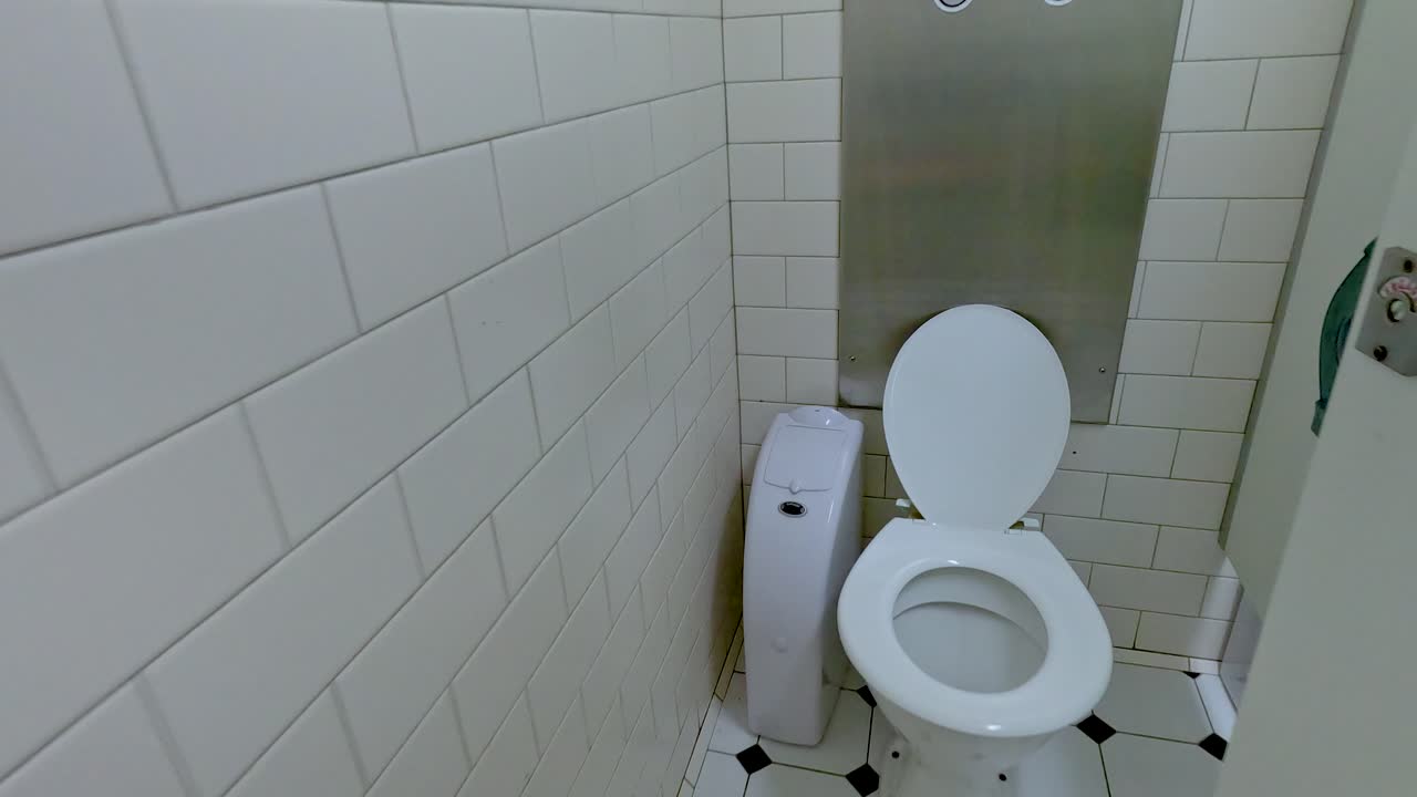 A sequence showing a clean, tiled public restroom with a toilet in Melbourne, Australia, captured with steady lighting and angles