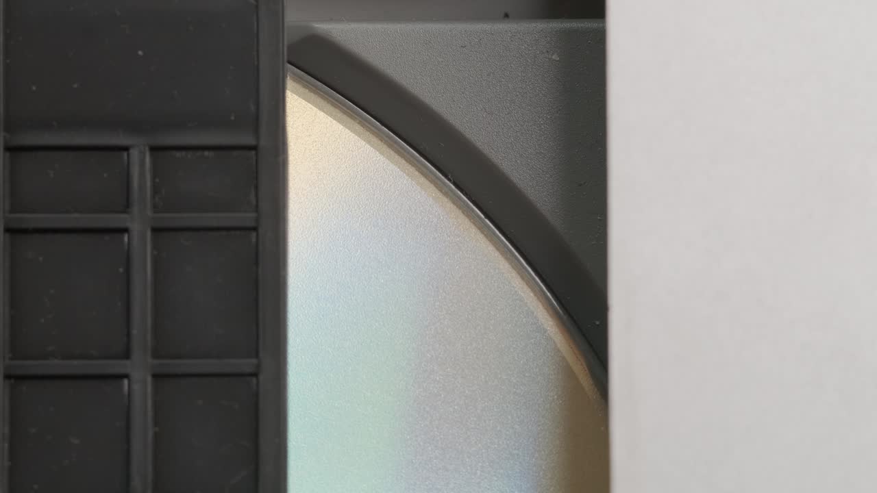 dvd-cd плеер внутри вида. цифровой видеодиск, вставленный в поднос, входит в плеер. вращение диска. закрыть