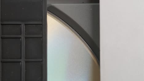 dvd-cd player inside view. digital video disc, inserted in tray, enters the player. disc rotation. close up