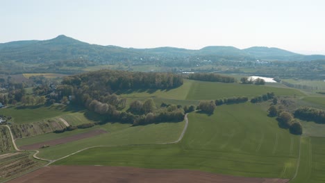 Drone---Aerial-panorama-shot-of-a-meadow-with-grass-and-bushes-and-the-Siebengebirge---seven-mountains-in-the-background-25p