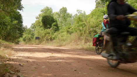 hombre en moto adelanta a una mujer en bicicleta mientras ella espera