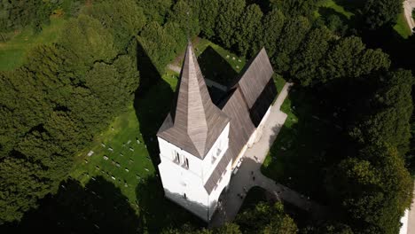 big church on a green meadow, cemetery, visby, sweden, drone