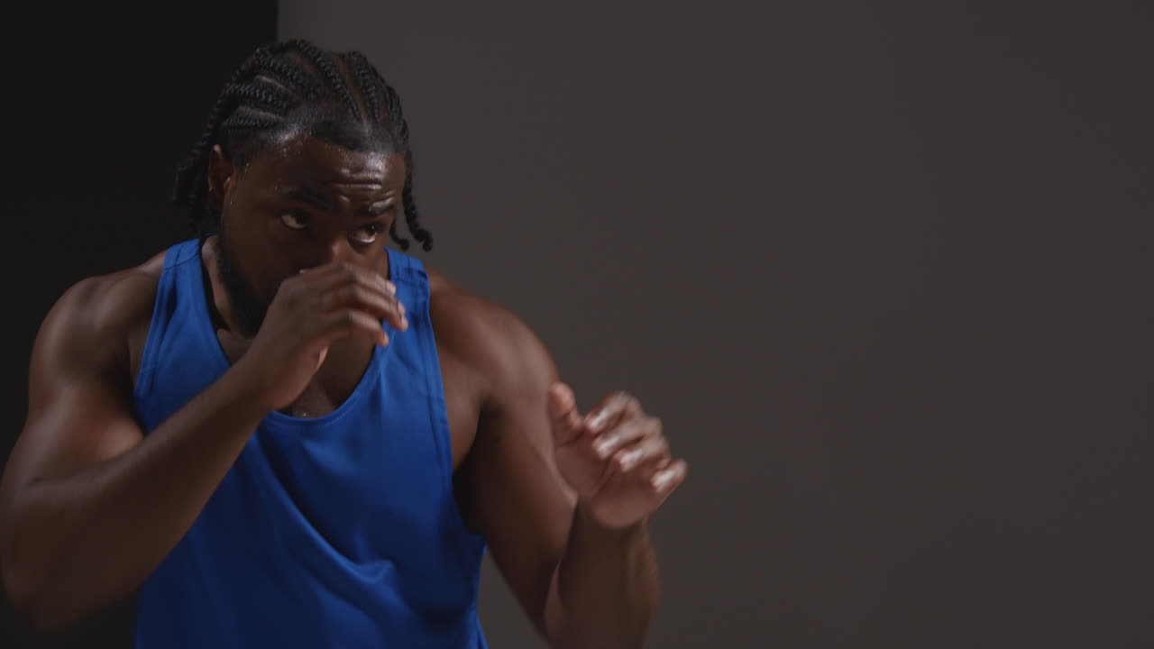 Studio Shot Of Male Boxer Training In Gym Sparring And Sweating Warming Up Preparing For Fight