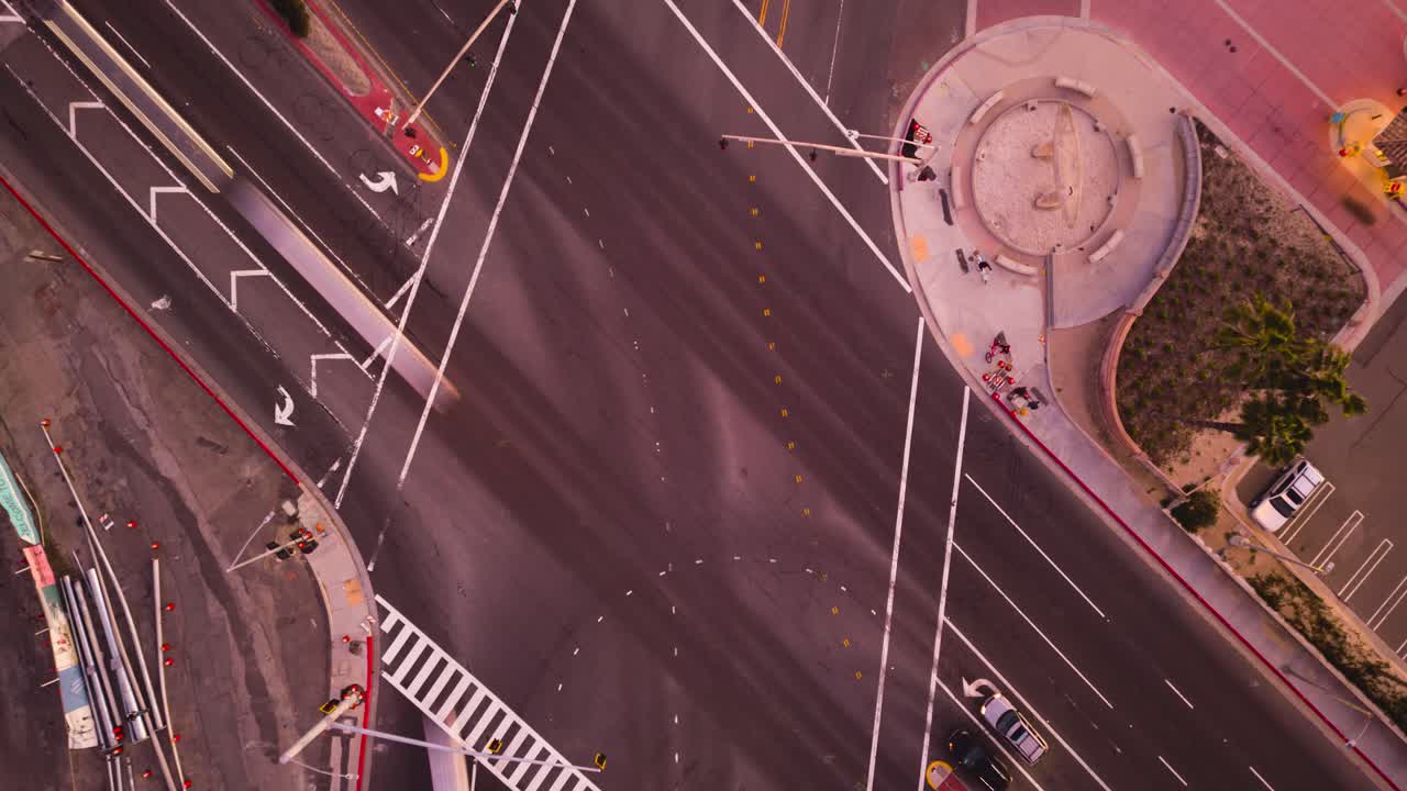 해변 대로와 태평양 해안 고속도로의 교차로에서 이 활기찬 드론 저속 촬영으로 러시아워의 번잡함과 번잡함, 아래를 내려다보는 일몰의 변화하는 색상