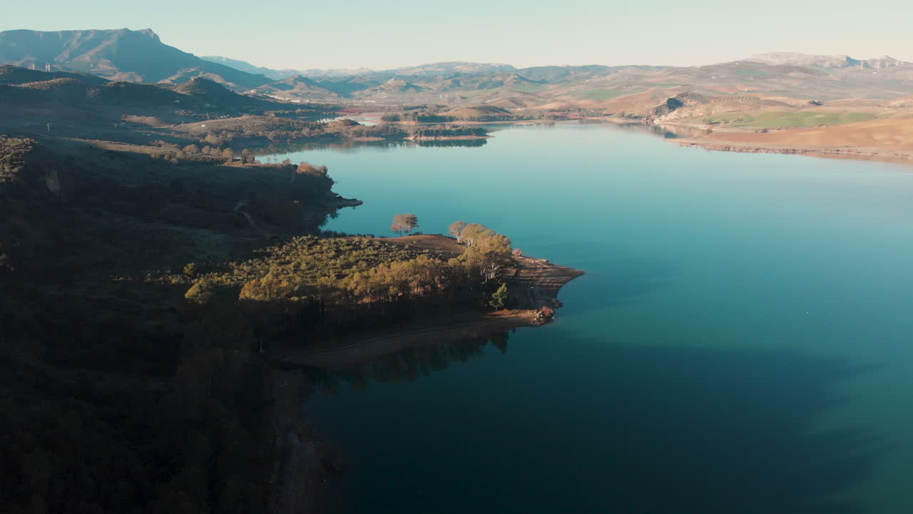 Acqua blu smeraldo circondata da foreste verdi e montagne in una giornata di sole in Grecia - ripresa aerea con drone.