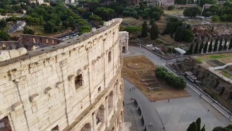 evening drone shot capturing rome’s ancient colosseum and constantine’s arch