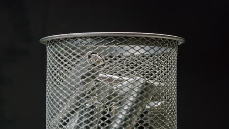 silver batteries aa and aaa falling into wastebasket close-up. double-a battery is a standard size single cell cylindrical dry battery. batteries are common in portable electronic devices. environmental impacts of lithium-ion batteries concept. an aa battery is composed of a single electrochemical c