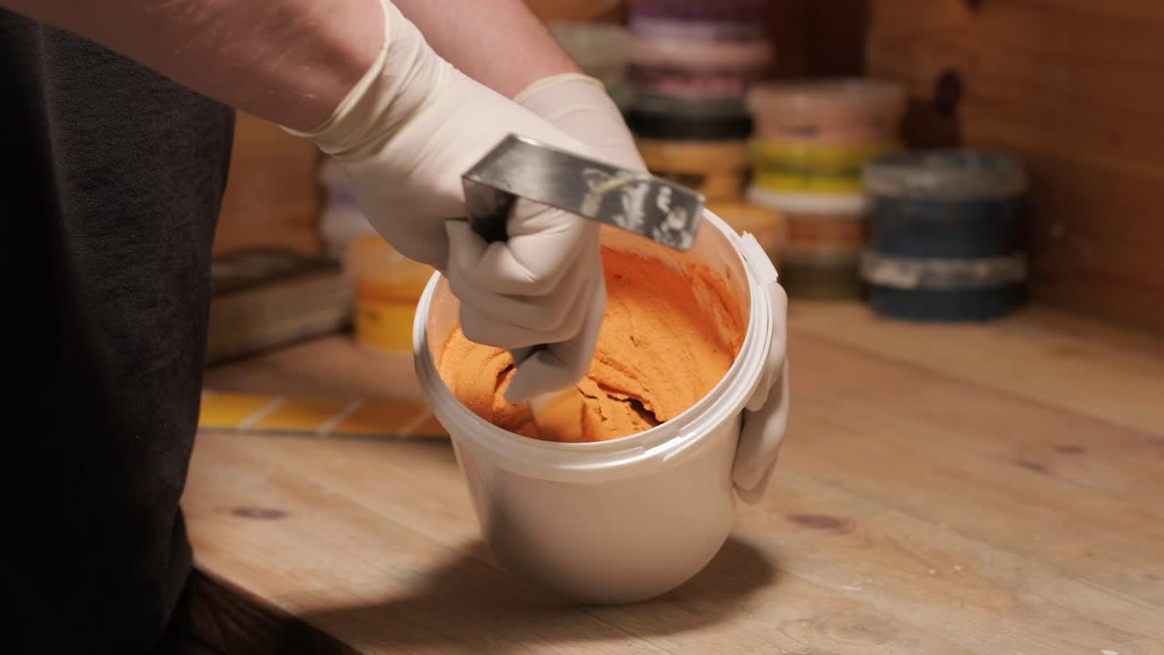 A worker kneads the paint for painting the walls