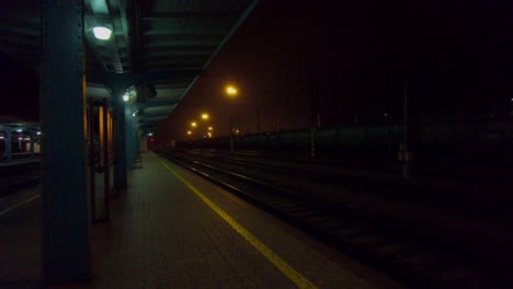 abandoned train station in the dark and lamp lights, standing train nearby. česká třebová, czech republic