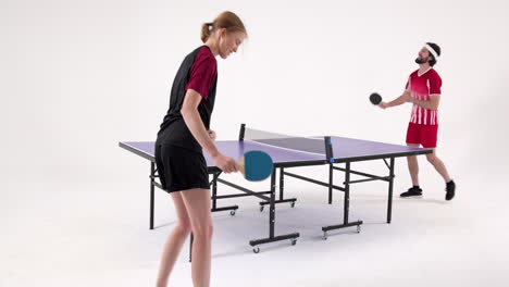 playing table tennis, two people enjoying game in indoor setting