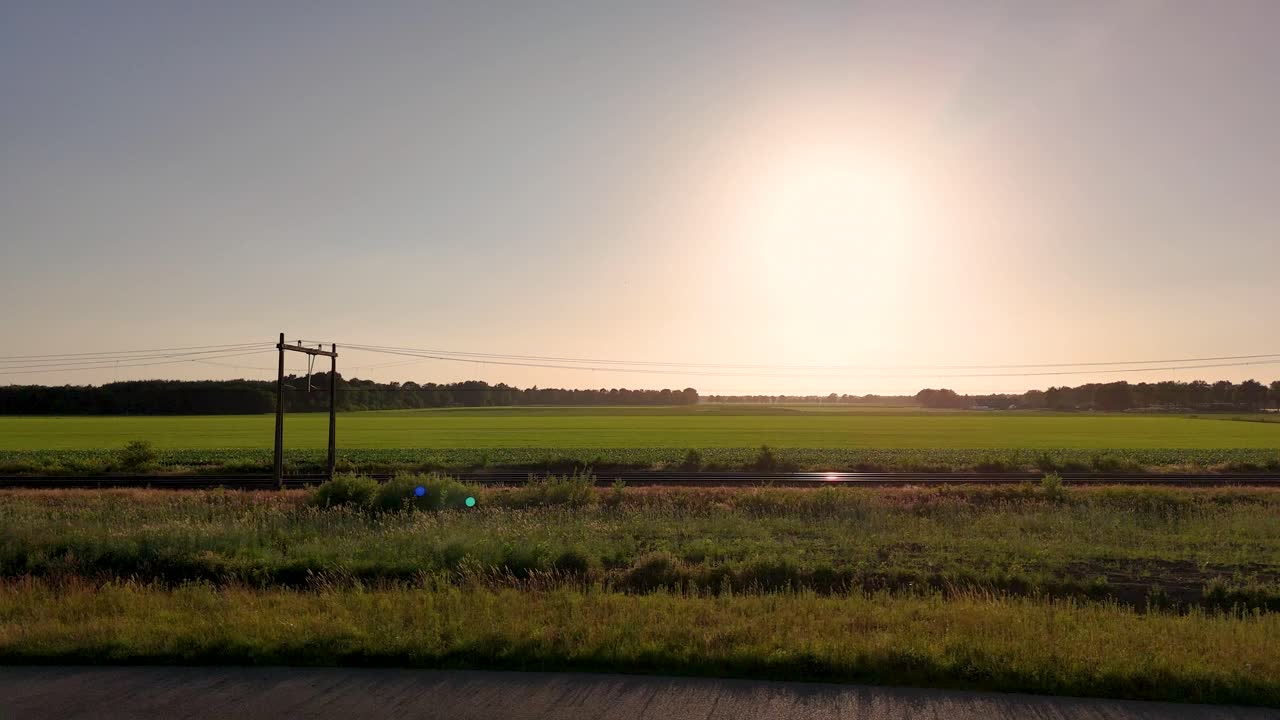 Sunset over a rural field and train tracks