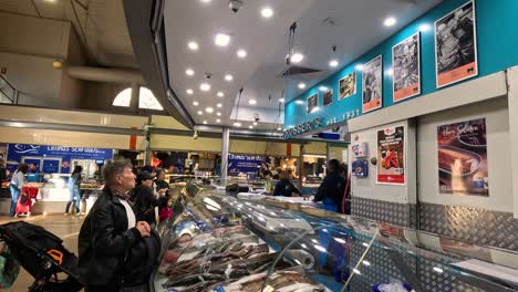 customer browsing fish and meat shop displays