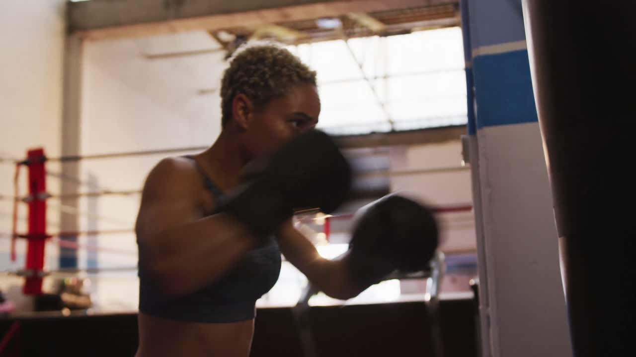 Mixed race woman boxing in punchbag