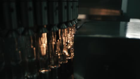 a bottling machine is filling plastic bottles with liquid in a large factory bottling plant