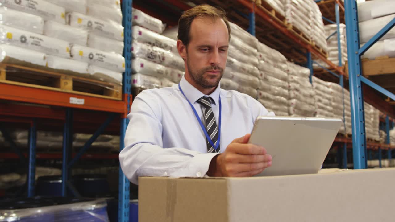gerente masculino usando tableta en el almacén 4k