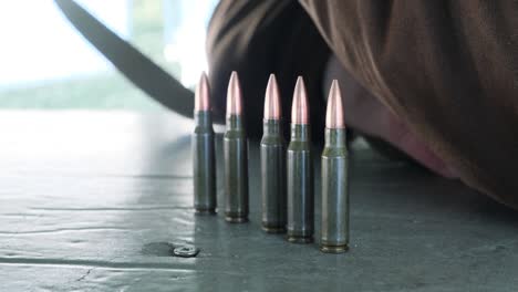 the cartridges are in a row on the table, prepared for firing a firearm. rifle bullets arranged on table. hunting ammunition.