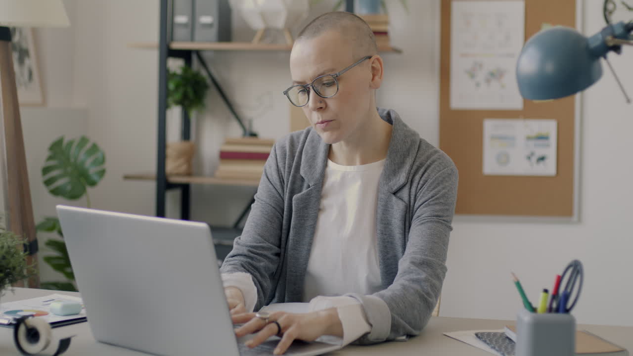 mujer trabajando en una computadora portátil en una oficina moderna