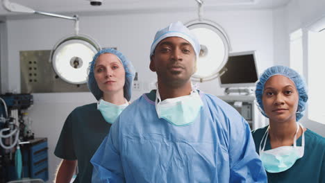 portrait of multi-cultural surgical team standing in hospital operating theater