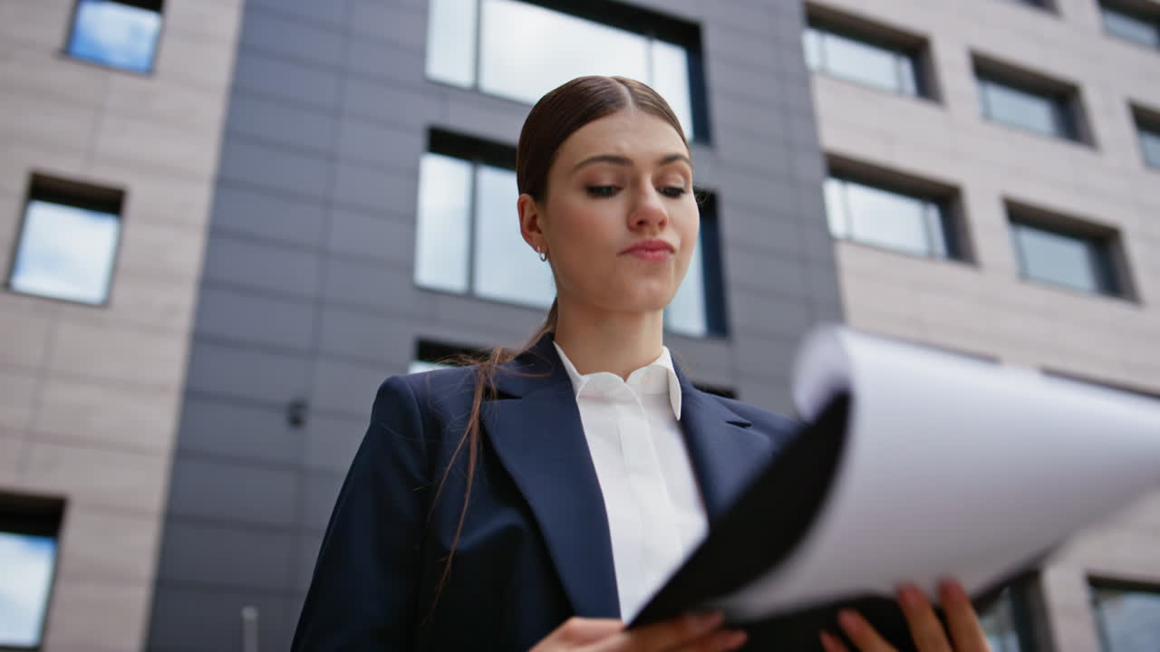Woman director examining papers feeling disappointed at business street closeup